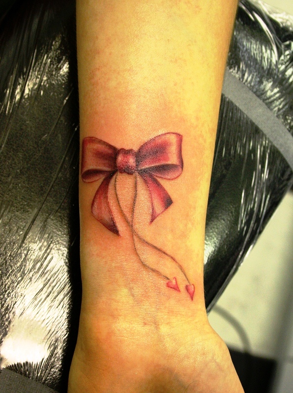 Attractive Red Bow Tattoo On Wrist
