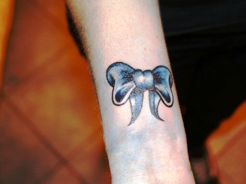 Black And Blue Bow Tattoo On Wrist