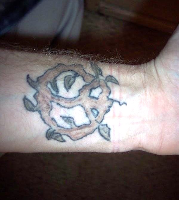 Brown Peace Tattoo On Wrist