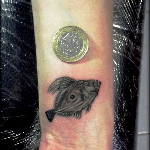 Little Black Fish Tattoo On Wrist