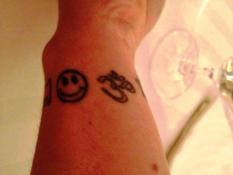 Smile And Om Tattoo On Wrist