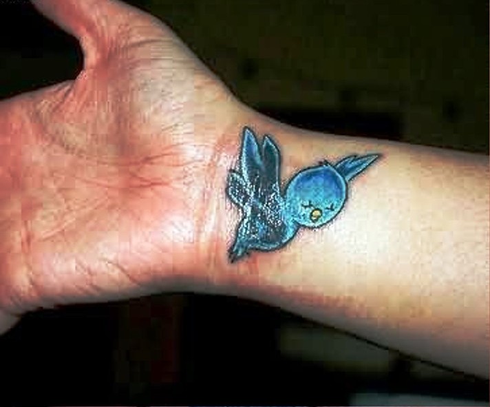 Tiny Cartoon Blue Bird Tattoo On Wrist