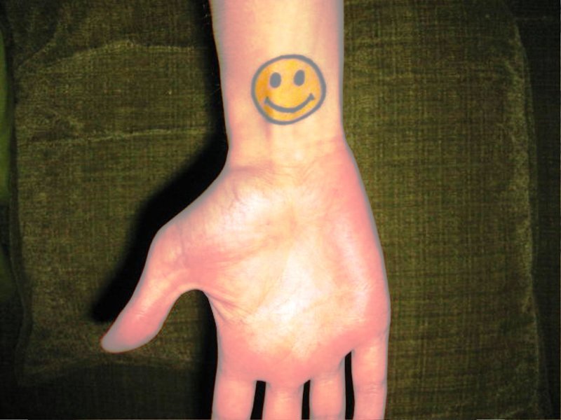 Yellow Smiley Tattoo On Wrist